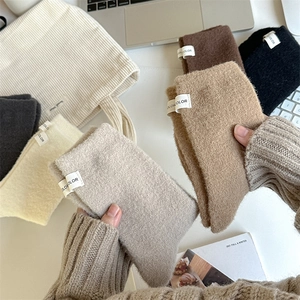 Close-up of thick thermal knit socks in earth tones with white fabric logo tags