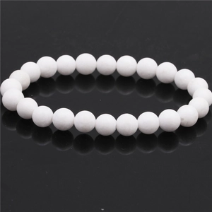 Detail view of 8mm matte white tiger eye agate beads on a minimalist beaded bracelet