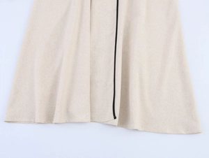 Dettaglio dell'orlo del vestito in lino beige con cucitura nera a contrasto