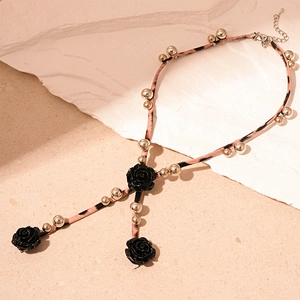 Détail du cordon en cuir léopard avec roses en résine noire et perles dorées
