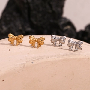 Detailed view of 18K gold and silver plated stainless steel ribbon bow stud earrings