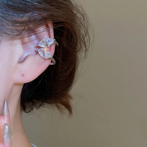 Gros plan d'une manchette d'oreille feuille en zircon avec cristaux sur l'oreille du mannequin
