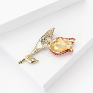 Detailed back view of a gold tulip brooch showing the safety pin fastener and metal texture