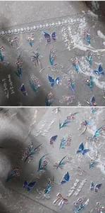 Macro detail of laser holographic nail stickers featuring butterflies and floral patterns