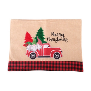 Detail of Christmas table mat featuring Santa, truck, and Merry Christmas text