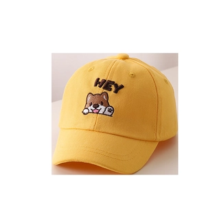 Dettaglio del cappellino giallo per bambini con ricamo a cucciolo e scritta HEY