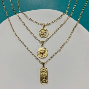 Gold layered necklaces with heart and evil eye pendants on paperclip chain links