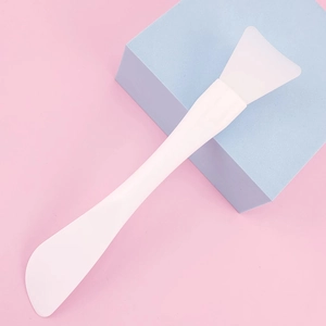 Macro detail of a white silicone facial mask brush on a pink and blue background