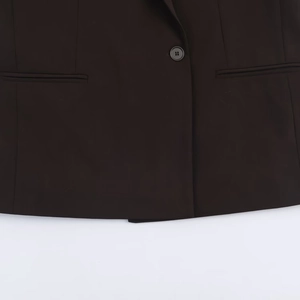 Détail d'une veste de costume croisée foncée montrant les boutons et les poches passepoilées