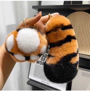 Close-up of fluffy tiger tail and paw keychains with orange and black stripes
