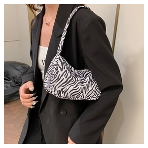 Gros plan du sac à bandoulière zébré avec texture noire et blanche sur le mannequin