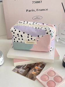 Detail of artistic canvas organizer bag featuring pastel color blocks and black polka dots