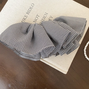 Dettaglio di un elastico per capelli a quadretti bianchi e neri su un libro vintage