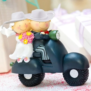 Mini white cowboy hats on a romantic resin wedding couple figurine riding a blue motorcycle
