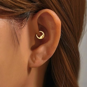 Gold F136 titanium crescent moon daith piercing earring featuring a detailed face relief
