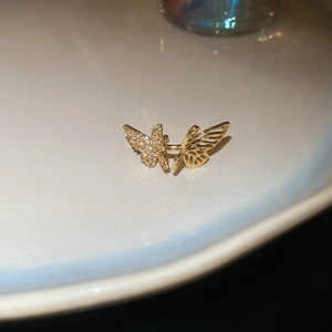 Macro shot of gold butterfly ear cuff featuring sparkling cubic zirconia and hollow detail