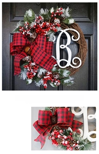 Detail view of a Christmas wreath with pine cones and a white monogram letter B decoration
