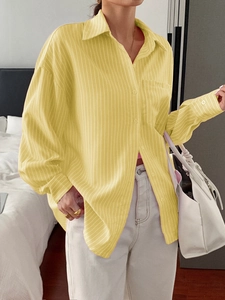 Detail of a casual long-sleeve yellow striped women's shirt with a button-down collar