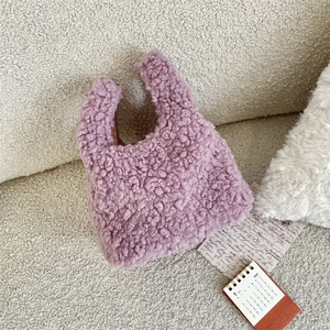 Detail of soft purple faux lamb wool texture on a compact furry handbag with U-handle