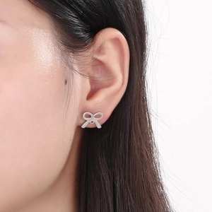 Close-up of elegant silver bow stud earrings worn by a model for a stylish daily look