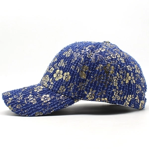 Blue denim baseball cap with vintage gold floral embroidery and textured woven fabric
