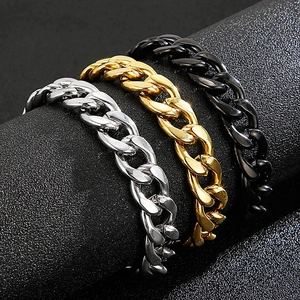Close-up of Cuban link bracelets in silver, gold, and black finishes on a display