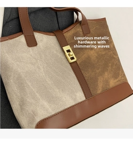 Close-up of contrast color tote bag with golden metal twist lock and textured fabric