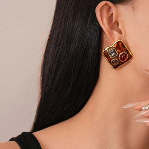 Close-up of vintage geometric square stud earring with three colored gemstones on a model