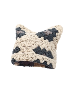 Detail shot of handcrafted crochet knit beanie featuring cute cat ears and beige texture