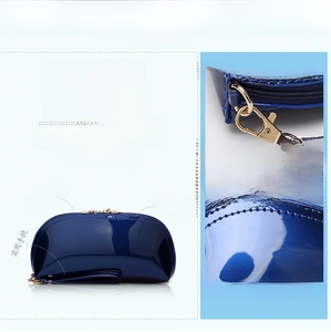Detailed view of glossy shell-shaped clutch with gold hardware and navy blue patent leather