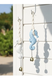 Detail of seahorse wall hanging decor with carved wood texture and golden bell