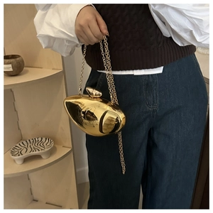 Detailed view of metallic gold mango-shaped clutch bag with long chain strap