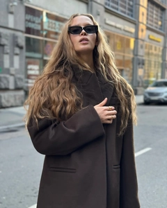 Detailed texture of dark brown wool coat with fringe and street fashion styling
