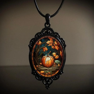 Detail of gothic raven necklace pendant featuring an autumn pumpkin and maple leaf motif
