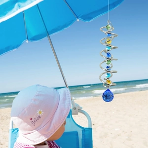 3D kinetic wind spinner stabilizer with colorful crystal beads and blue gazing ball on a beach