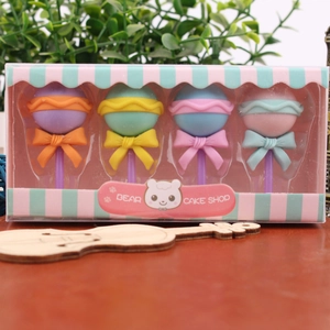 Close-up of four colorful lollipop-shaped stationery erasers in a striped gift box