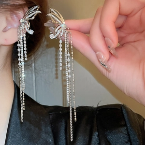 Close-up of sparkling zircon butterfly tassel earrings with silver chains and pearls