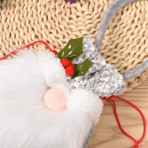 Detail of Christmas gnome gift bag featuring white beard and festive berry decorations
