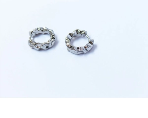 Détail de boucles d'oreilles créoles argentées avec surface métallique à texture lave