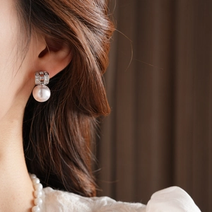 Close-up of elegant gold plated pearl earrings and matching necklace on a model