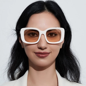 Detailopname van de witte oversized zonnebril met amberkleurige glazen op een model