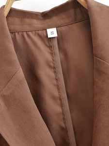 Detailed macro shot of the coffee brown blazer collar and size S woven neck label