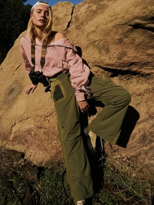 Detail of pink half-zip hoodie and green cargo pants with pockets for outdoor wear