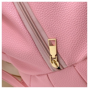Close-up of pink pebbled faux leather texture and gold-tone zipper on bear backpack