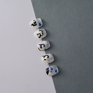 Detail view of 5D embossed nail art stickers featuring cute winter penguins and blue fish