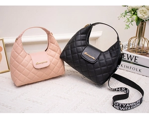 Close-up of pink and black quilted handbags with branded logo and colorful patterned straps