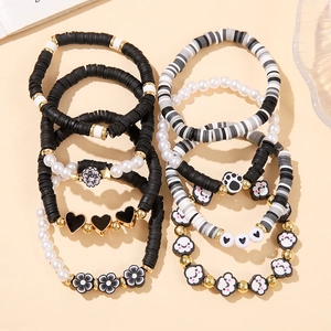 Detail of 8-piece stackable beaded bracelet set with black heart and flower charms