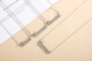 Close-up of Aries, Taurus, Gemini, and Cancer gothic font zodiac sign necklaces in silver