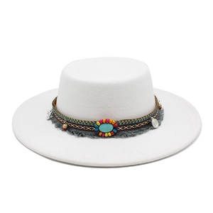 Détail de chapeau en feutre blanc avec perles bohèmes, pierre turquoise et franges