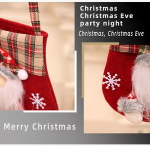 Détail d'une chaussette de Noël avec motifs à carreaux et figurine de Père Noël en 3D